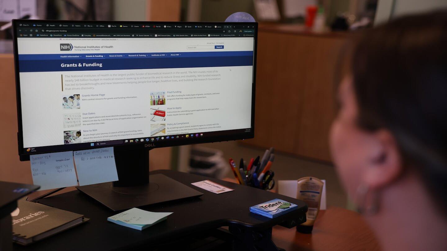 A desktop screen displays the NIH grants and funding website