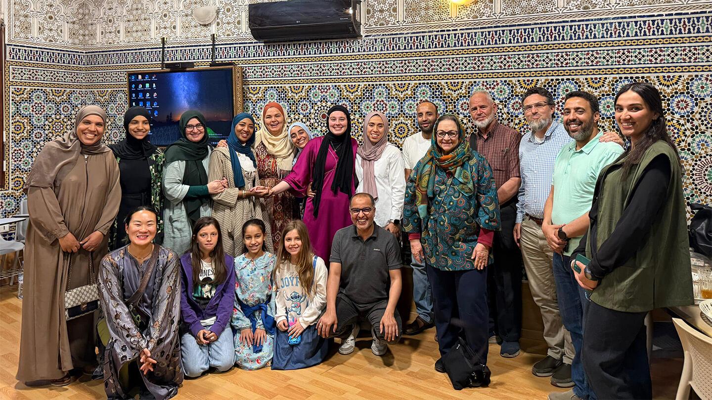Large group of Moroccan women, girls, and men in beautiful tiled room in Marrakech, Morocco