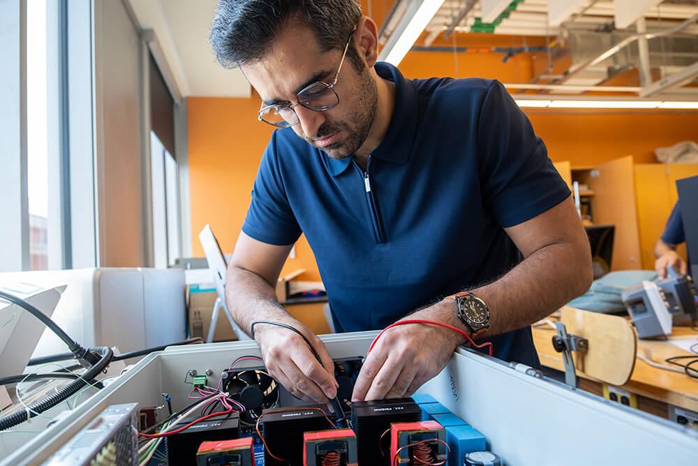 Graduate Research Assistant Arash Omidi examines electrical inverters used in the ATL