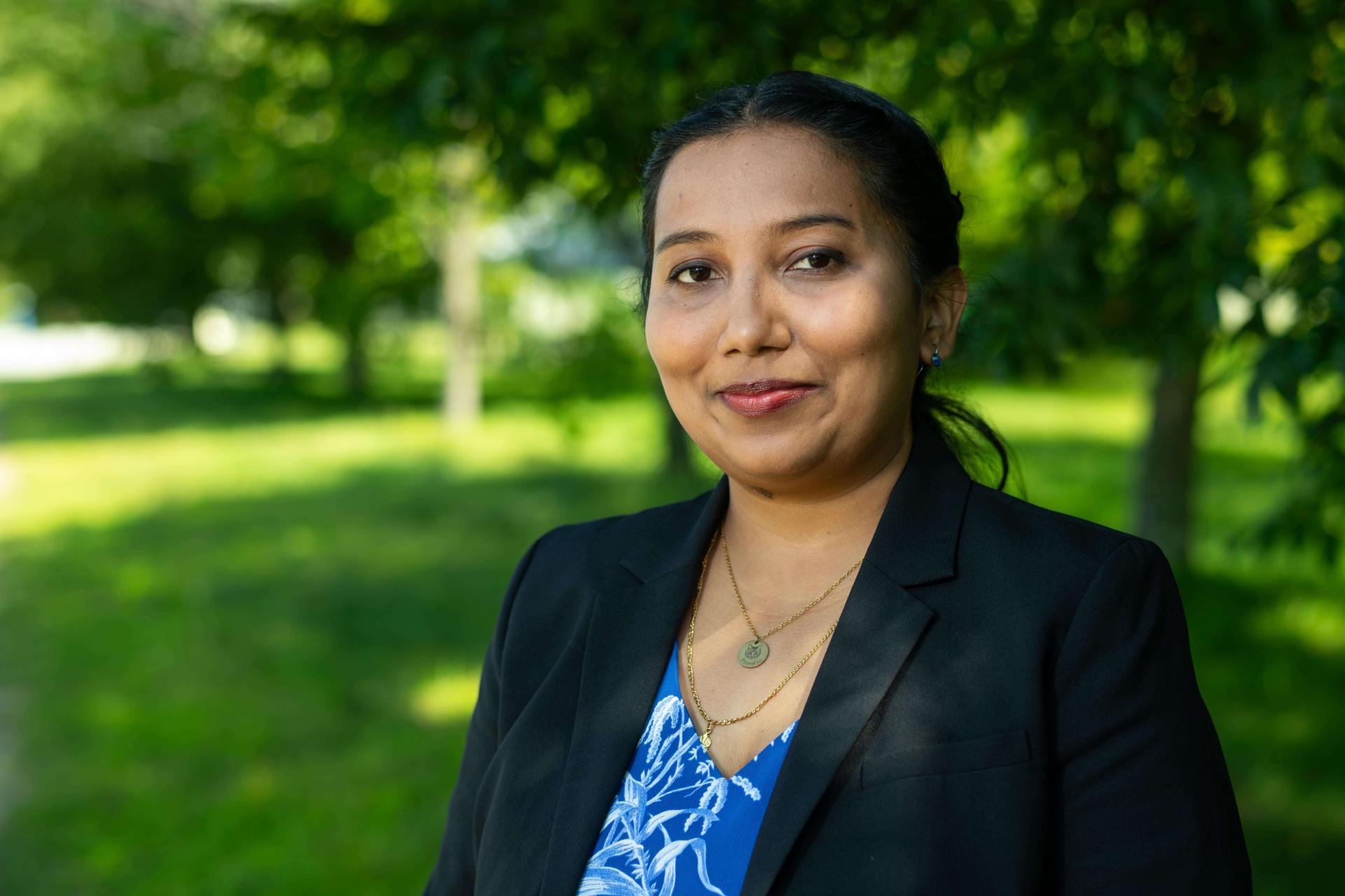 A woman dressed in a blazer standing outside -- headshot 