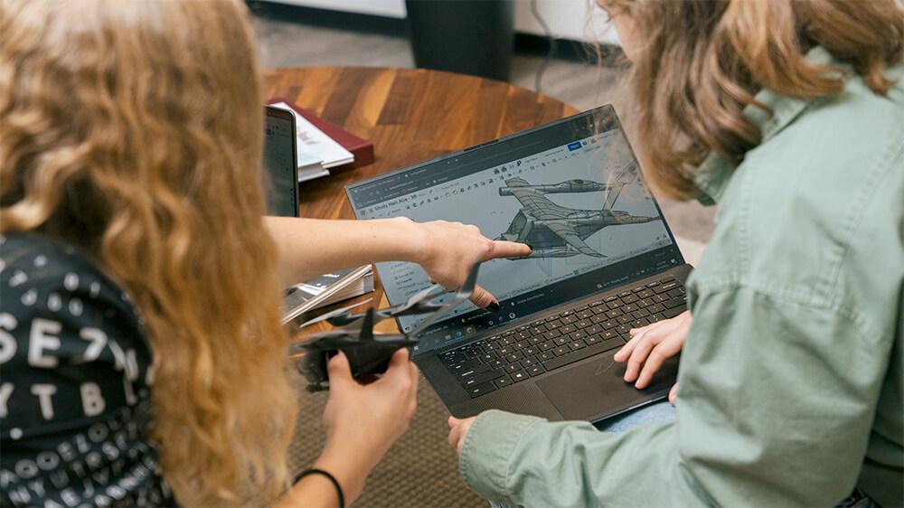 Researchers collaborate on a project on a laptop