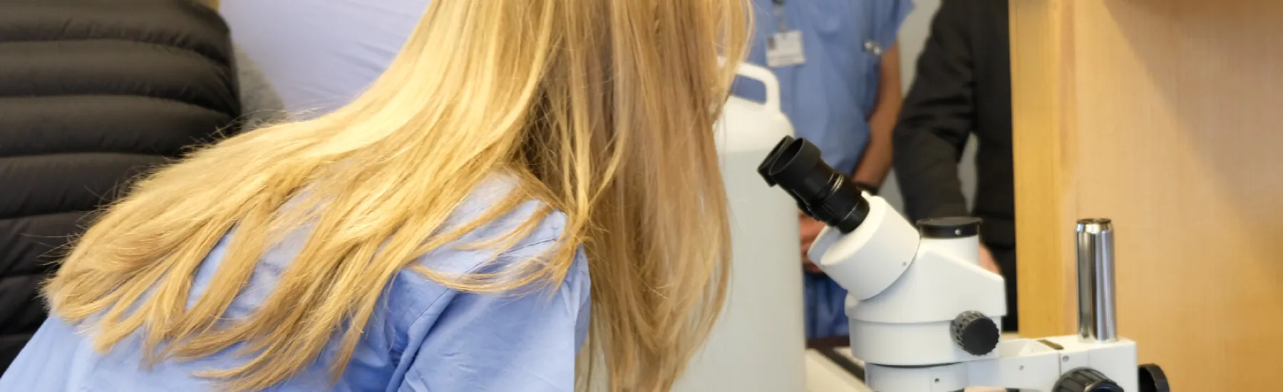student looking into a microscope