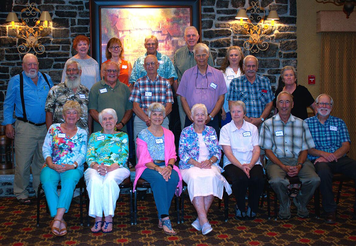 group of 28 people standing in two rows and sitting in one row 
