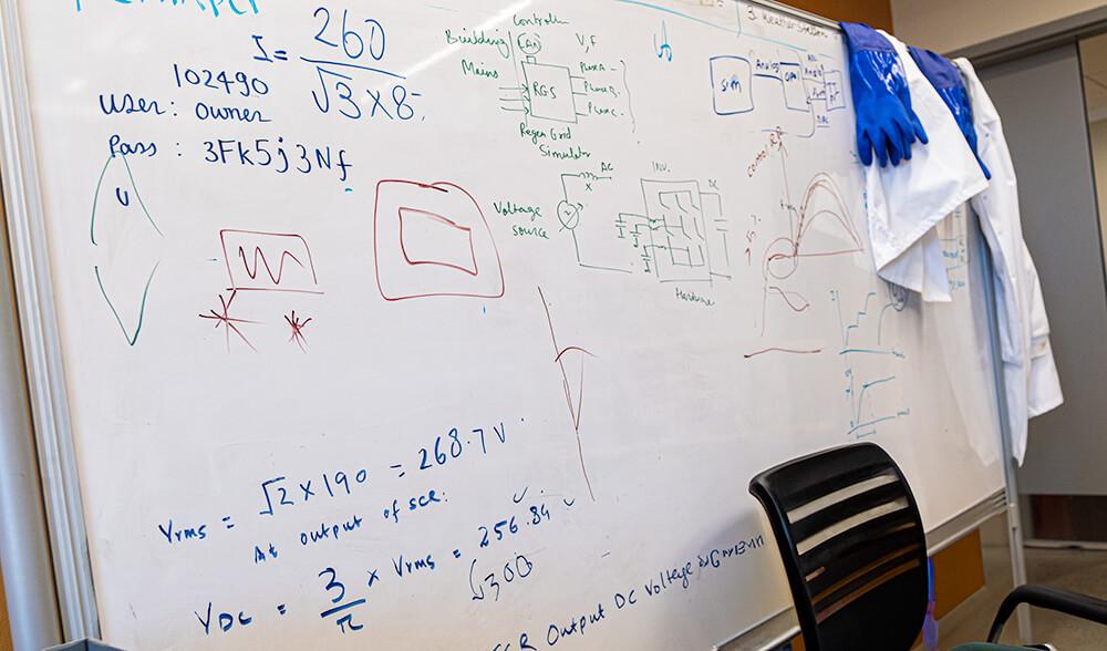 A whiteboard including hand-drawn diagrams and equations