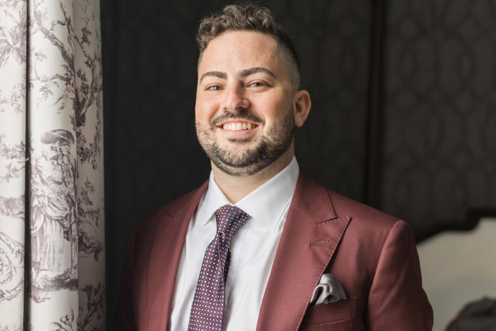 A smiling man in a suit and tie.