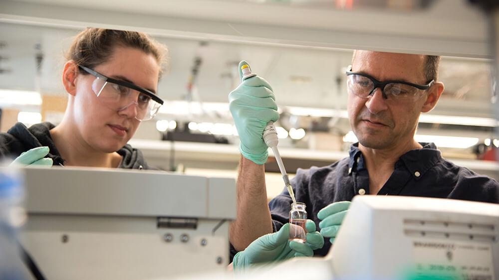 Professor Christopher Landry works with a graduate student in his chemistry lab