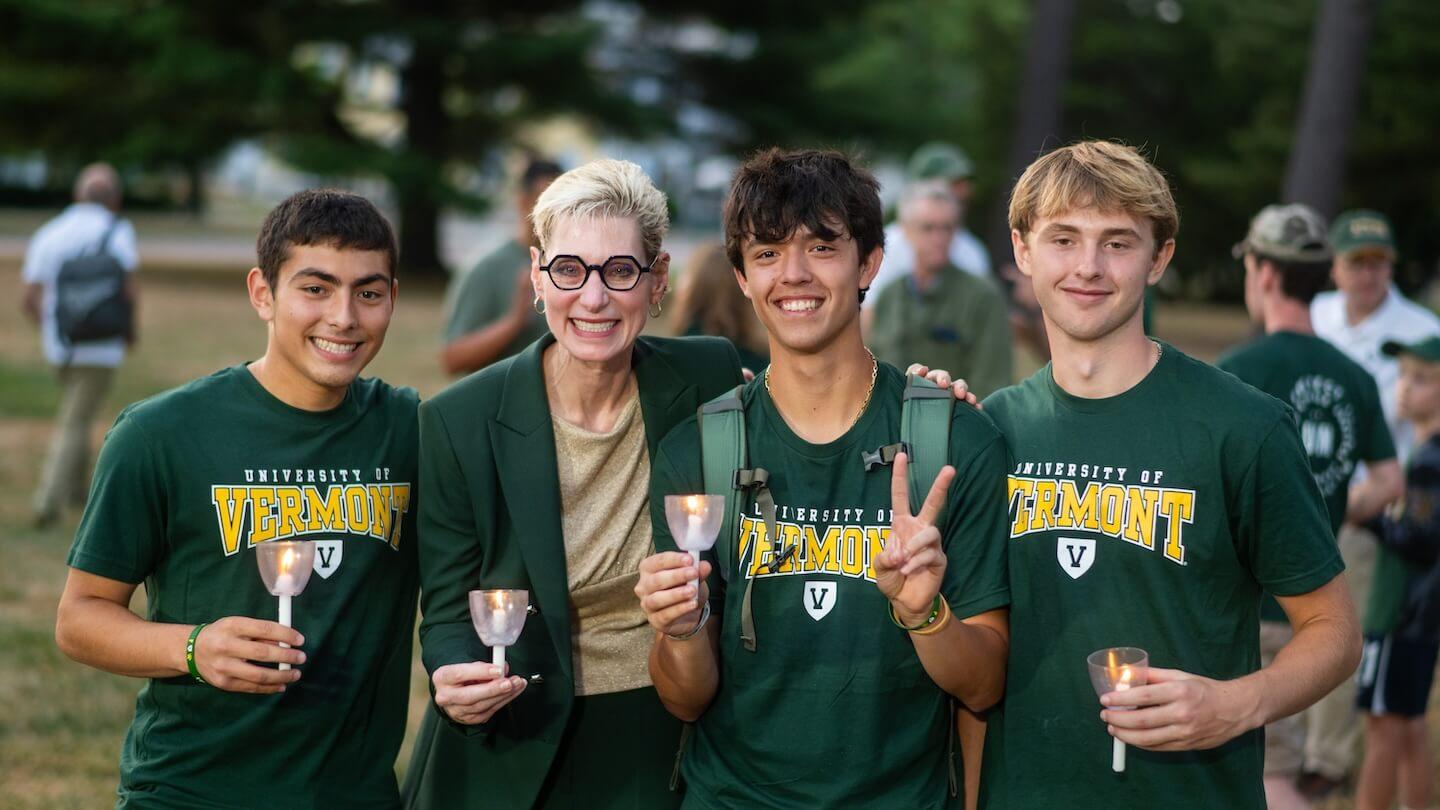 A group of four people standing on the UVM Green