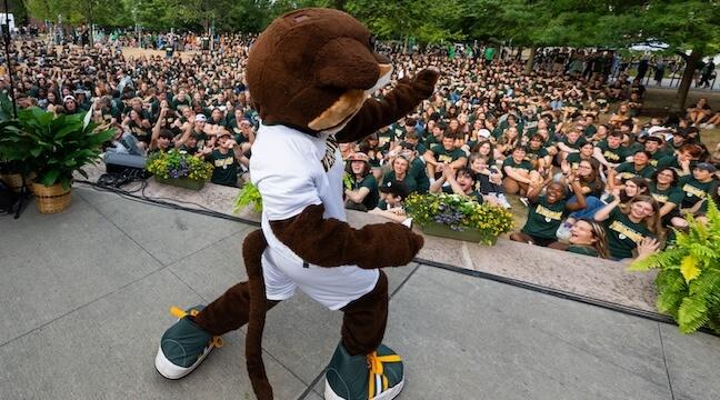 The UVM mascot working a crowd of students
