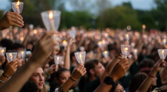 A crowd of UVM students holding up candles.