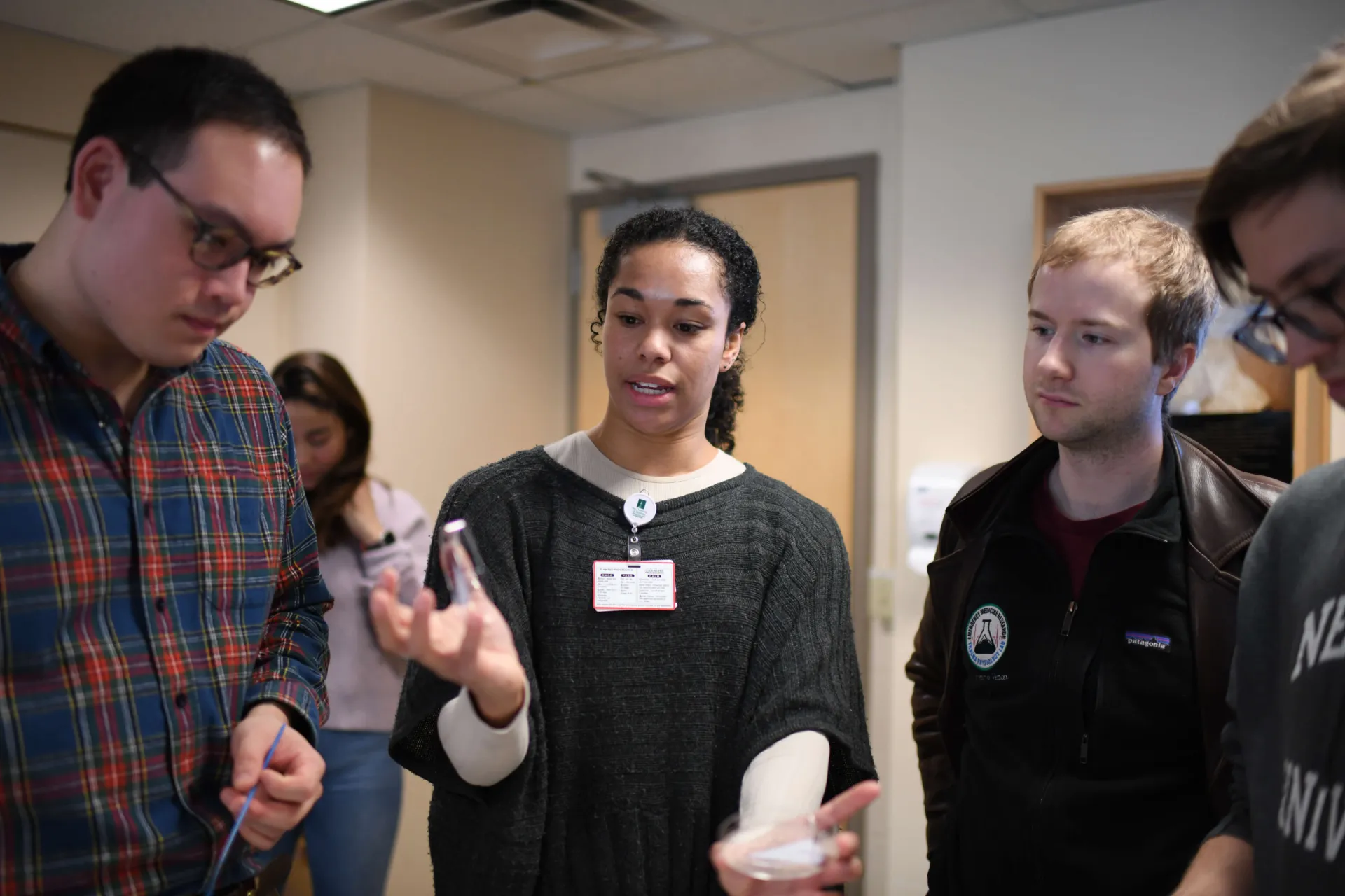 Instructor teaching group of students in microbiology class
