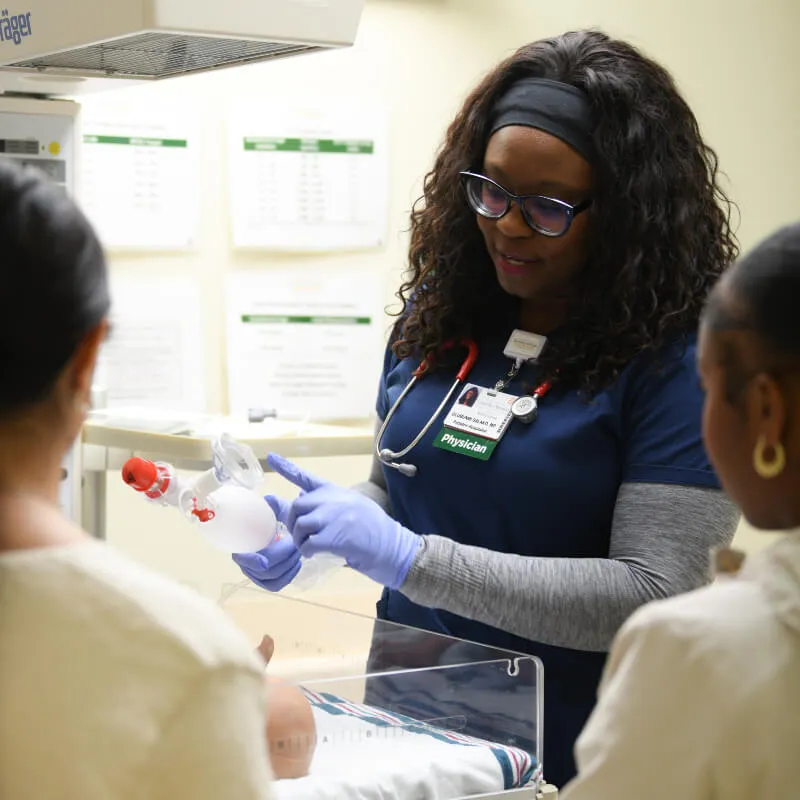 Physician showing medical device to two students