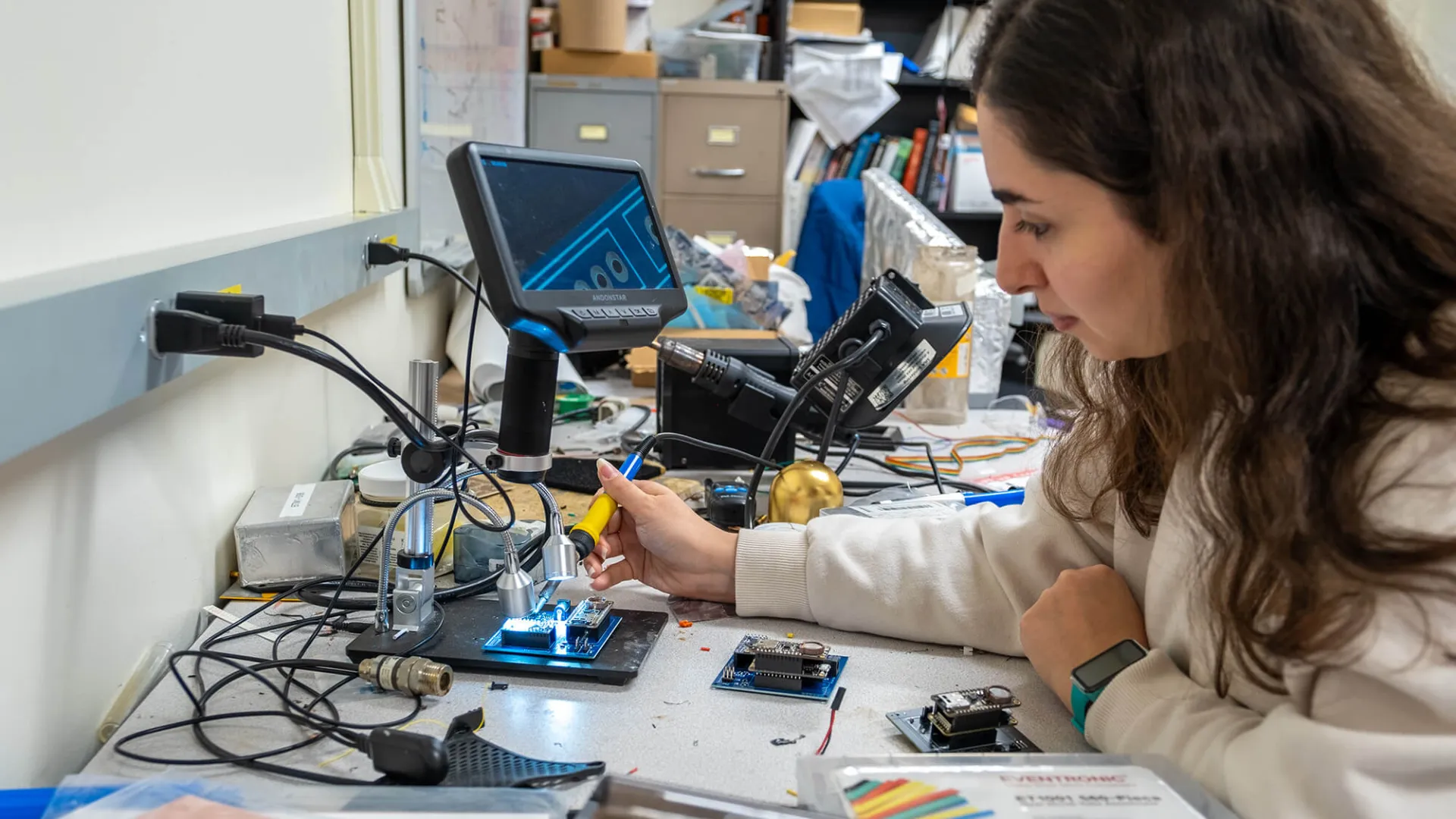 Graduate student testing a circuit board in a CEMS lab