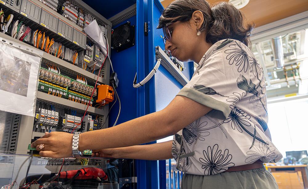 A graduate student working on lab equipment