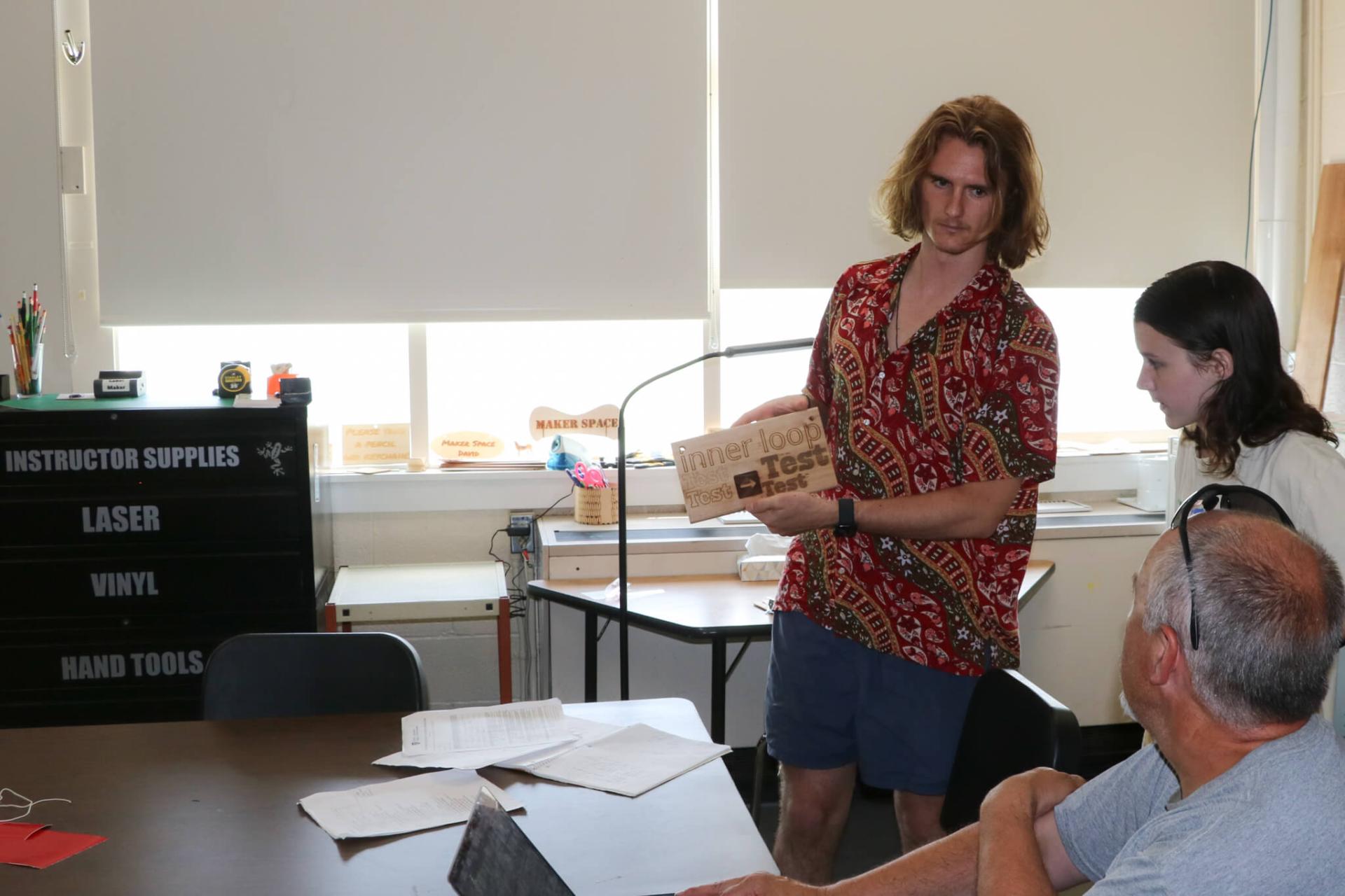 Robbie McKersie '25 shows off the custom fonts for Bethel's community trail network signs