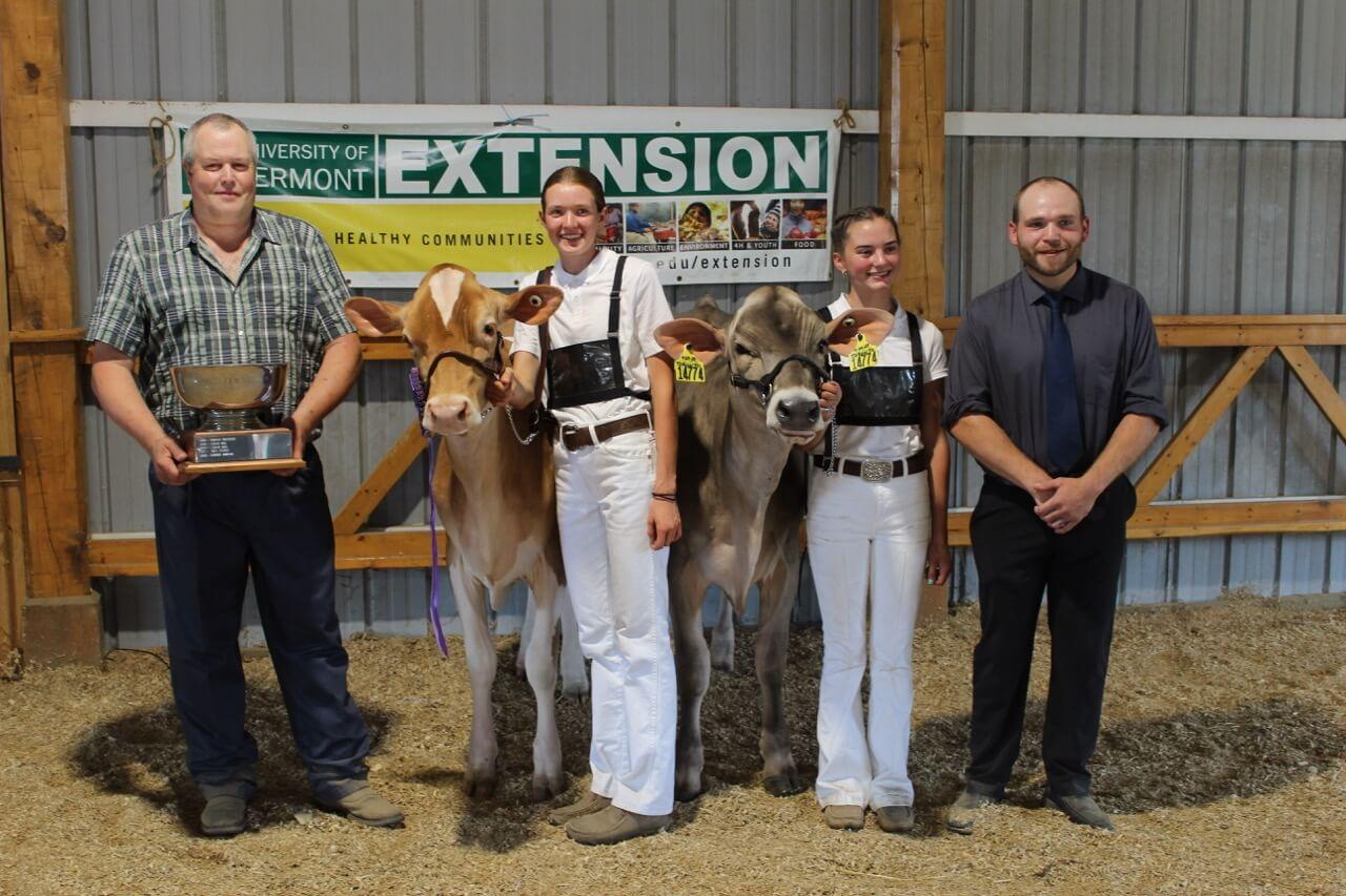Two 4-H'ers and their cows with two judges