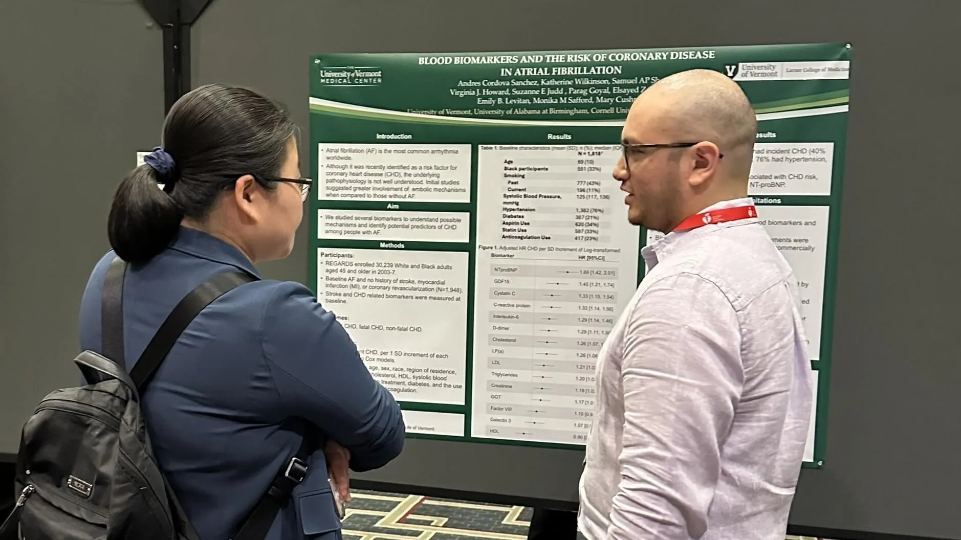two researchers in front of poster