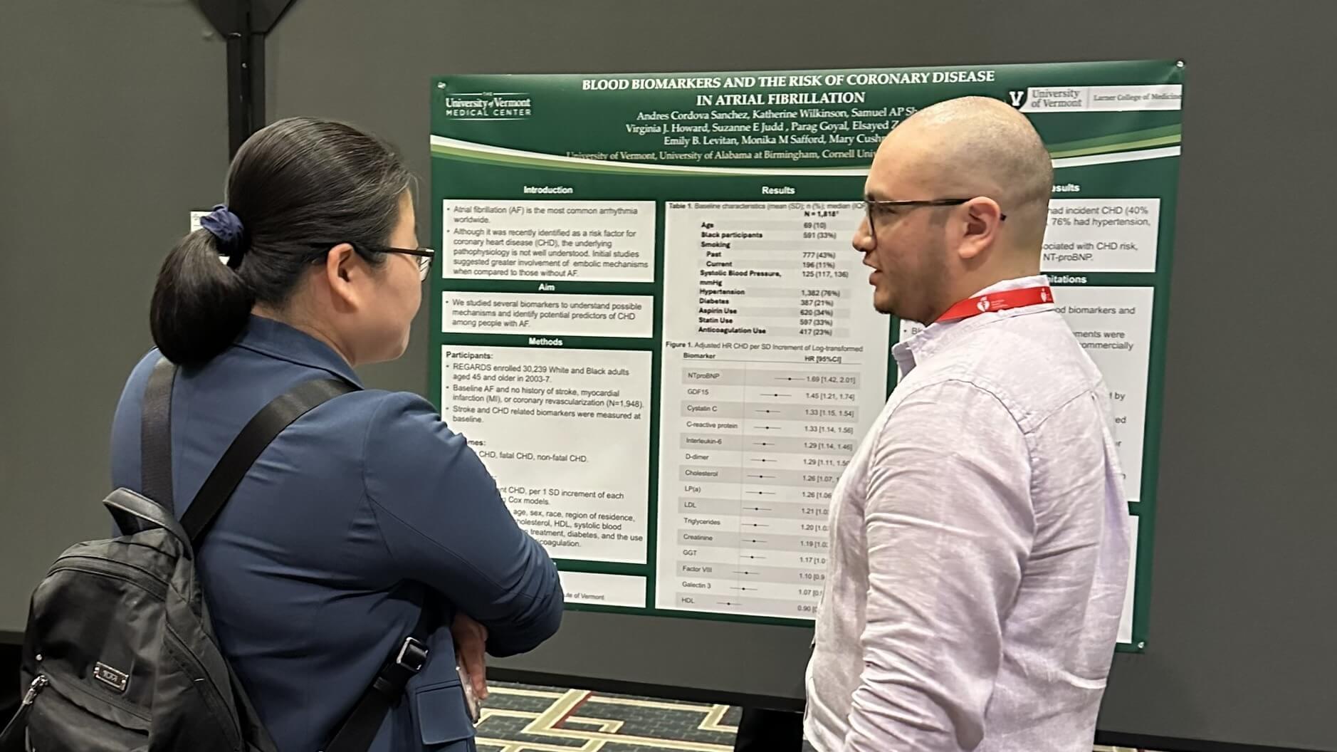 two researchers in front of poster
