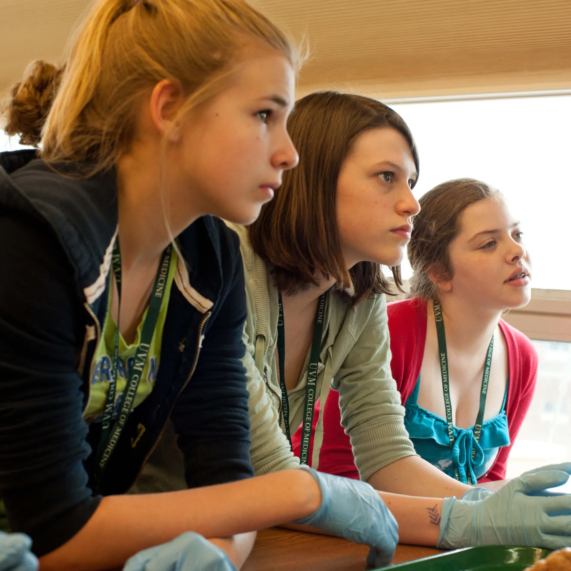 three middle schoolers listening intently