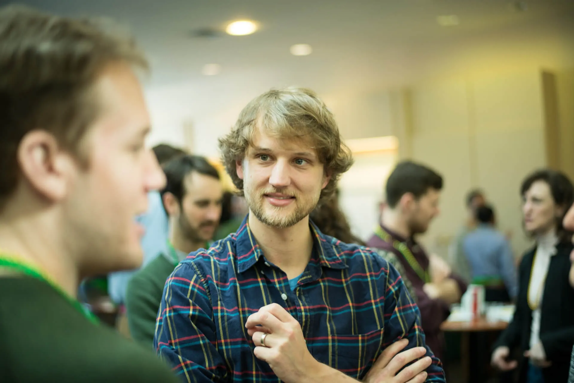 two guys chatting in a crowded room