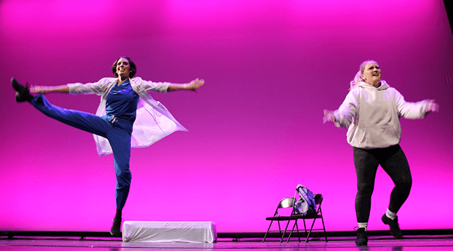 2 people dancing on a pink-lit stage