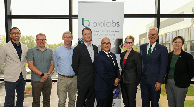 a group of people standing in front of a BioLabs banner