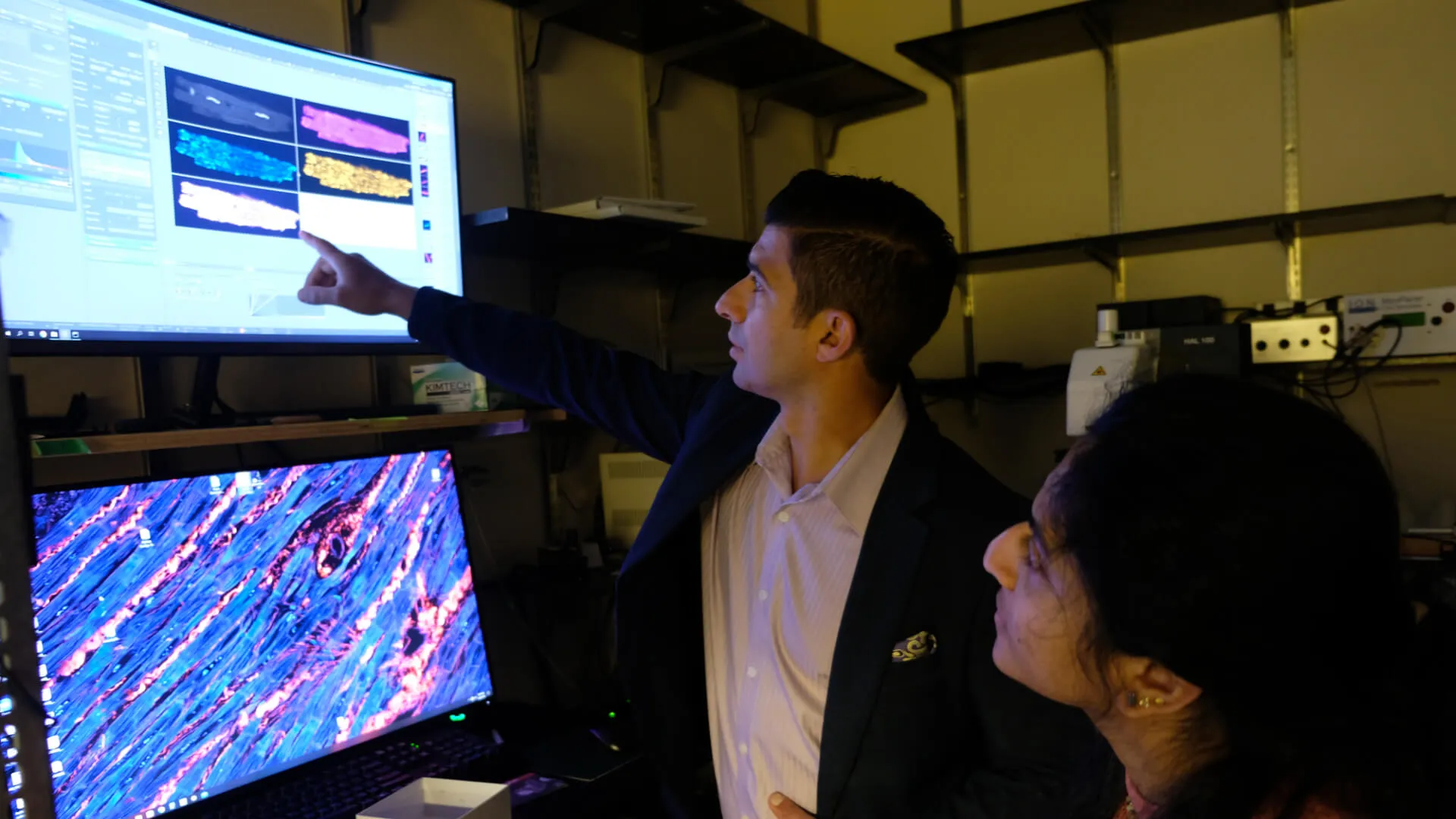 two researchers looking at research images on a screen
