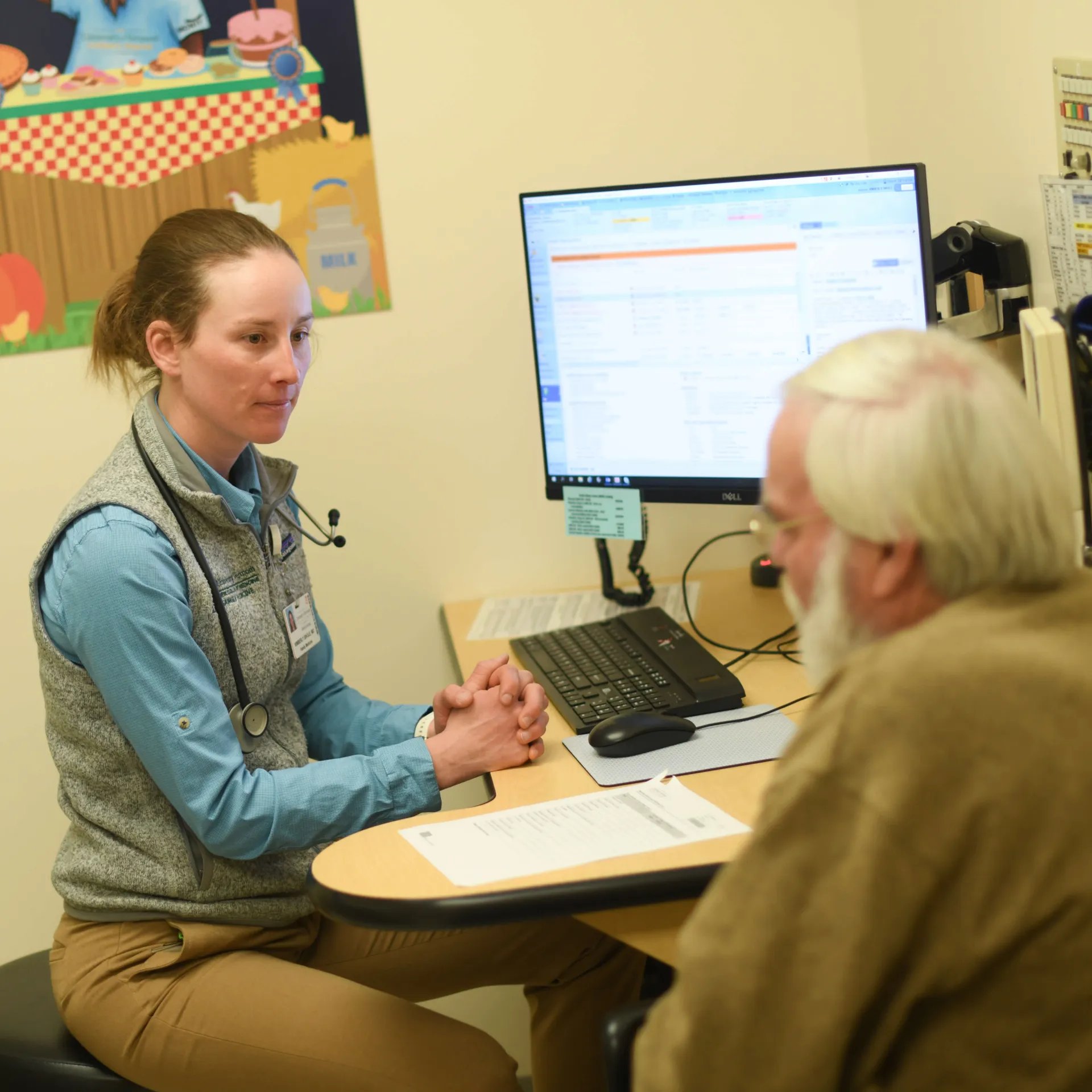 doctor listens to a patient in an exam room