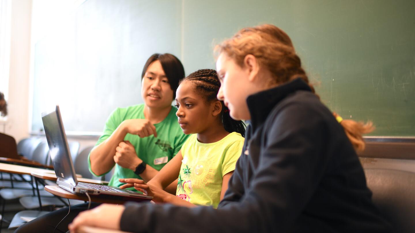 Students and a teacher working on a computer-based project