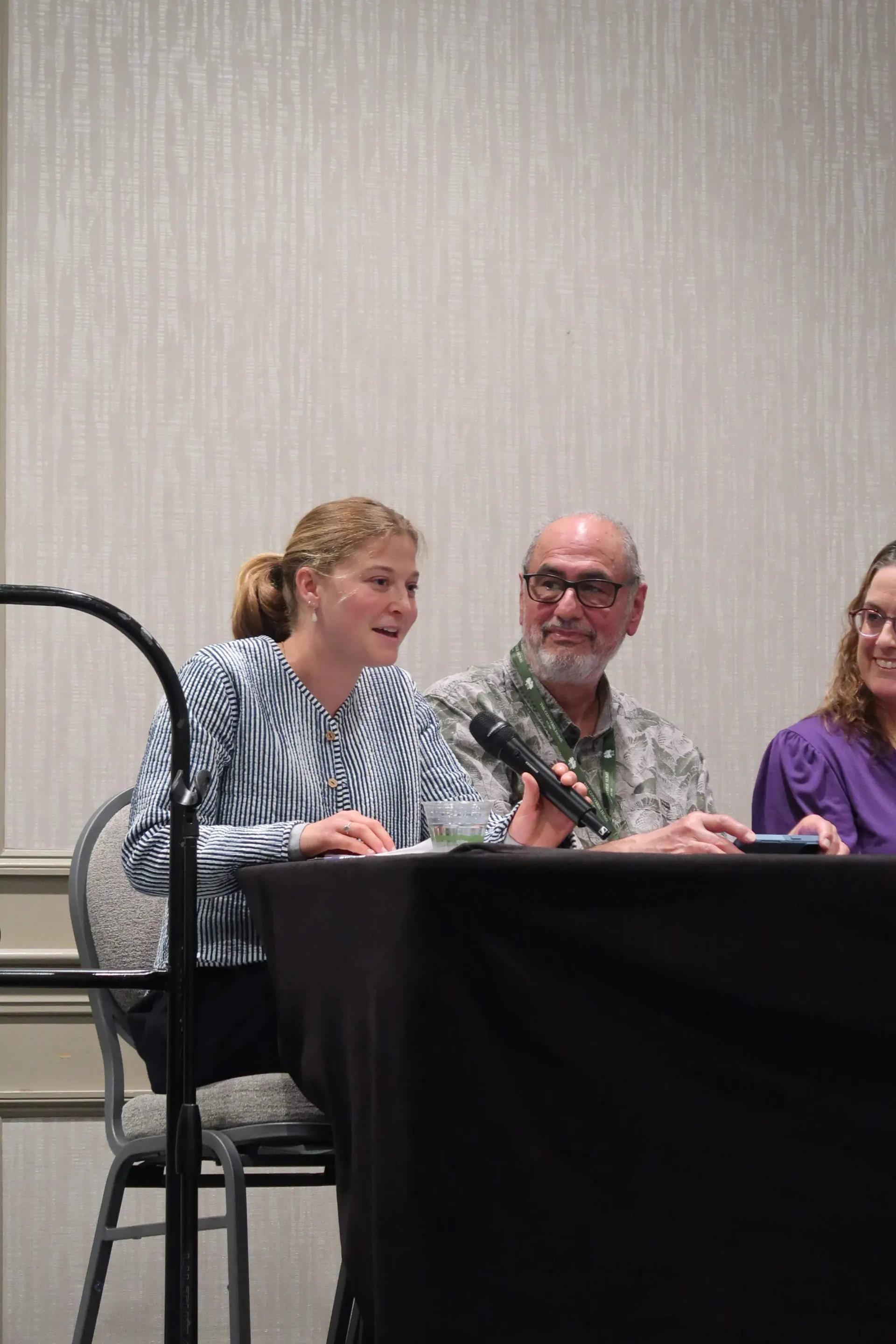 Panelist speaking into a microphone at Gerontology Symposium