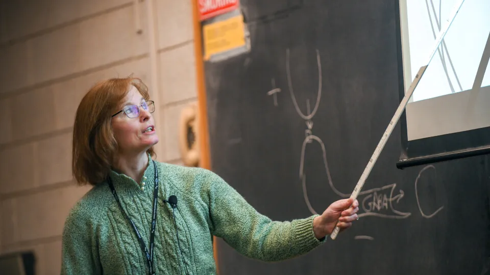person pointing with tool at a screen