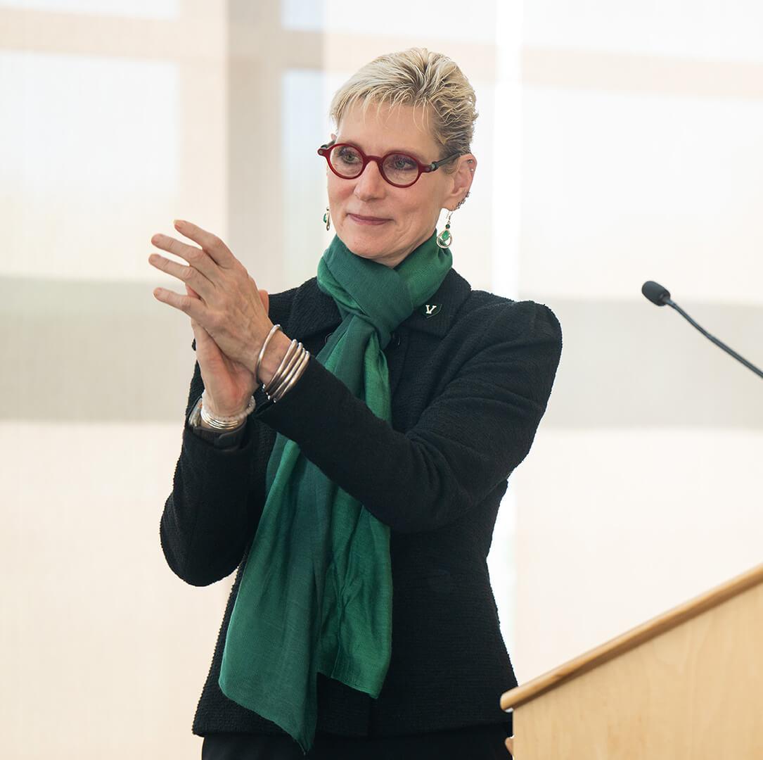 Marlene Tromp claps at a podium