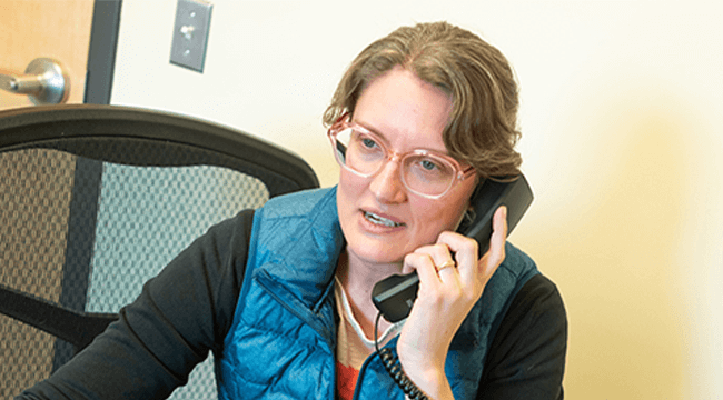 a person at a desk talking on a phone
