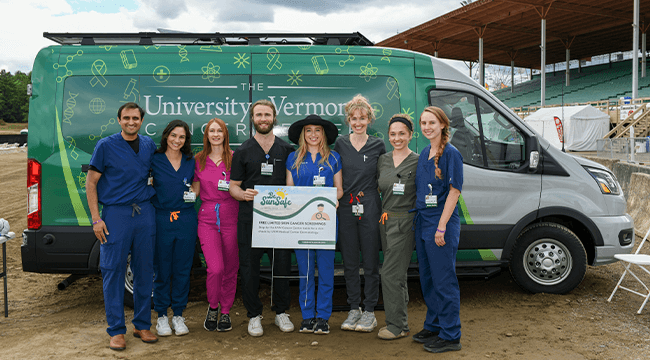 a group of health care providers standing in front of the UVM Cancer Center's Outreach & Education Van
