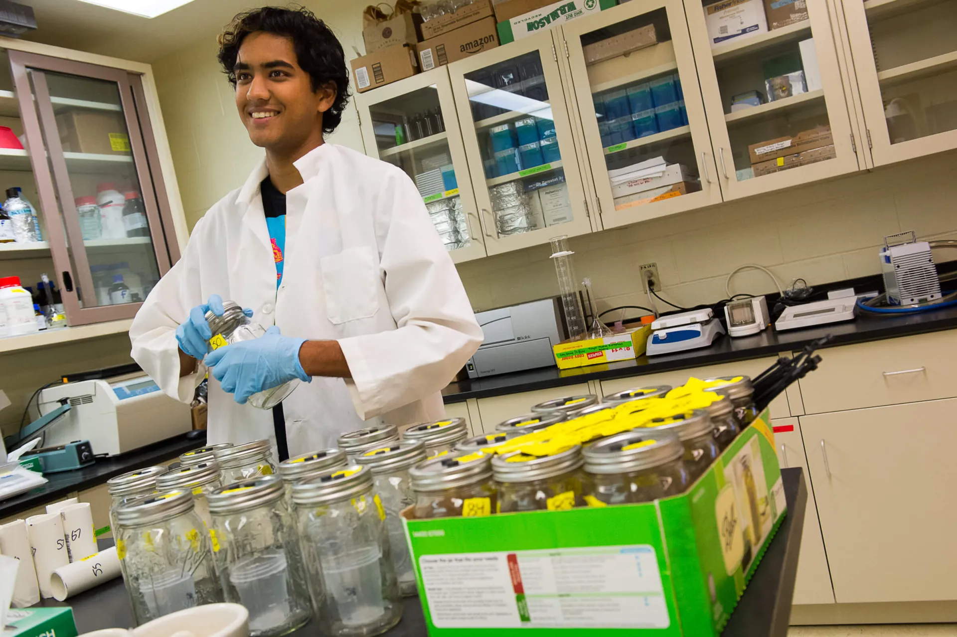 Man in white lab coat stands in lab