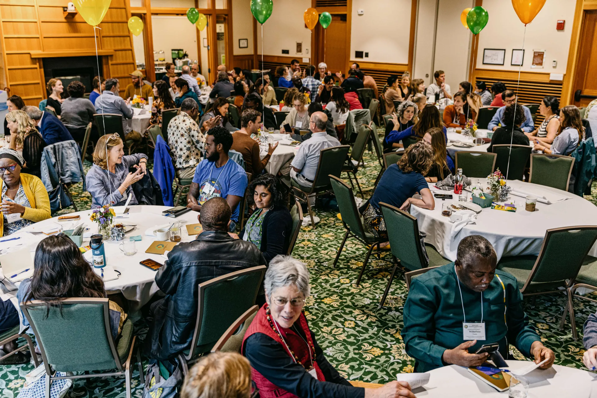 large group of people around tables in a hall