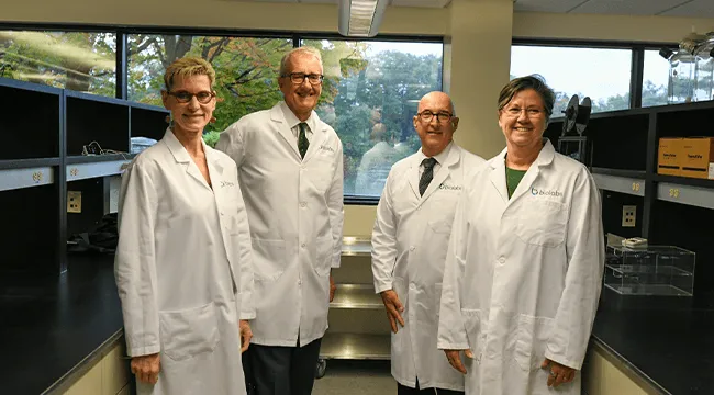 4 people in white lab coats