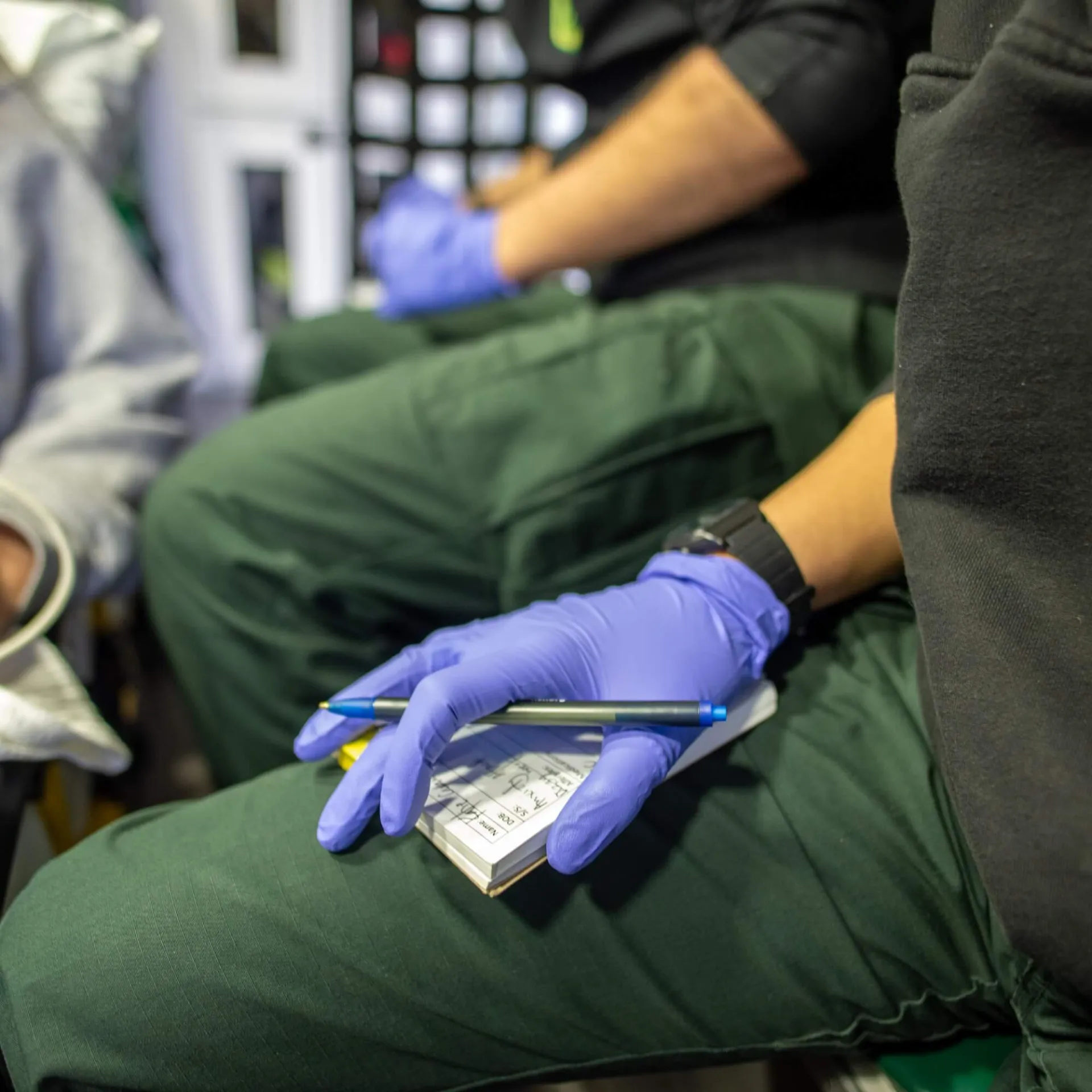 EMT holding notepad in back of ambulance