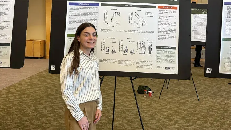 Student presenting a research poster at an academic showcase.