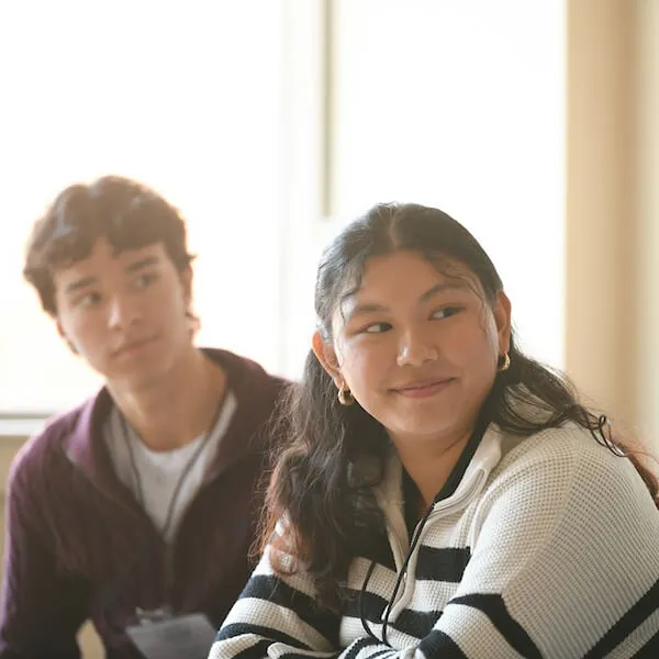 a young adult male and female sitting and listening