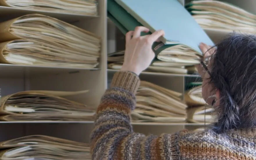 a woman filing specimens in an herbarium cabinet