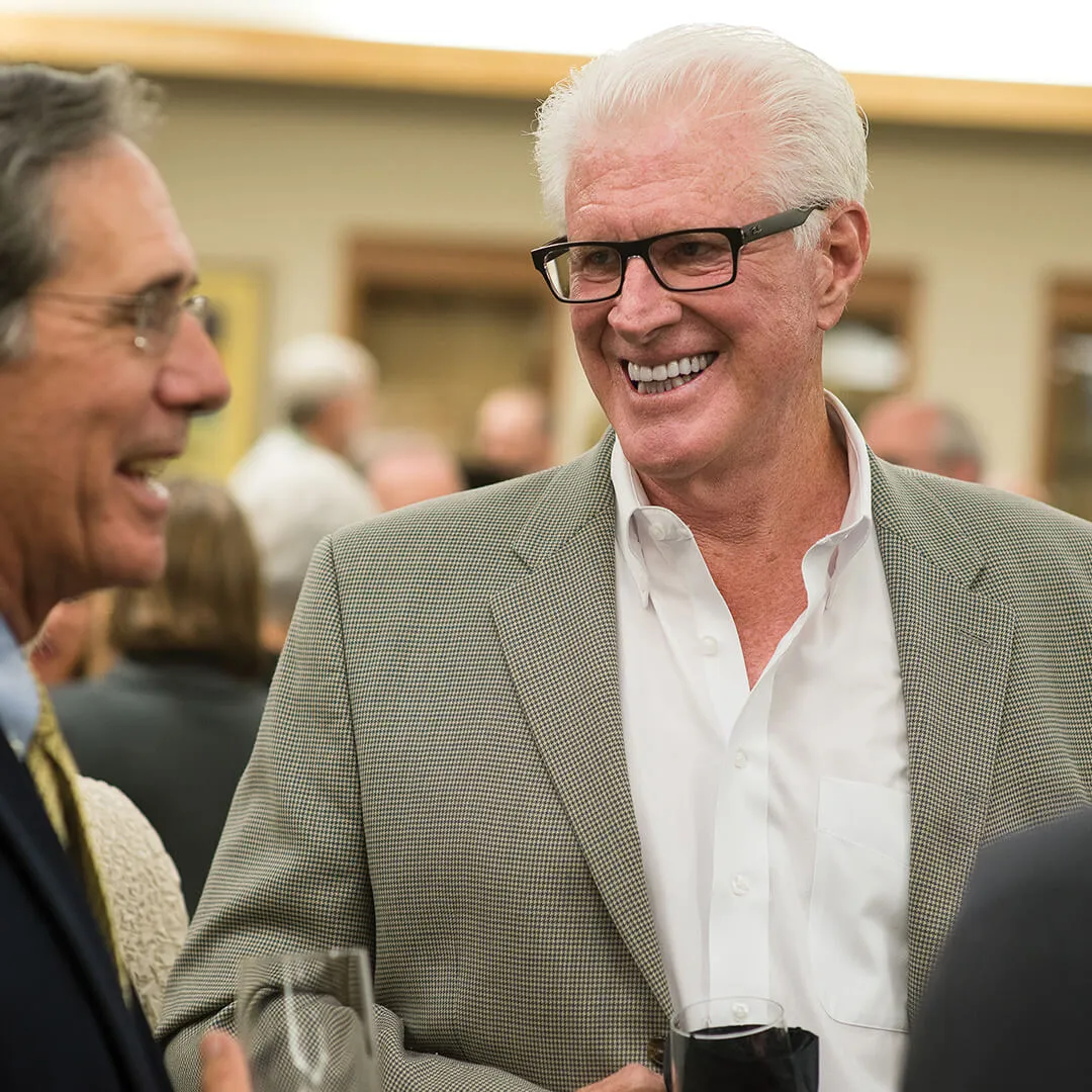 richard tarrant smiles at a person mid-conversation