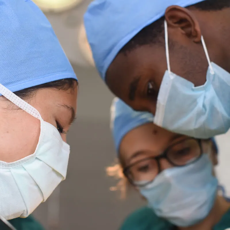 two surgery students and a surgeon in scrubs 