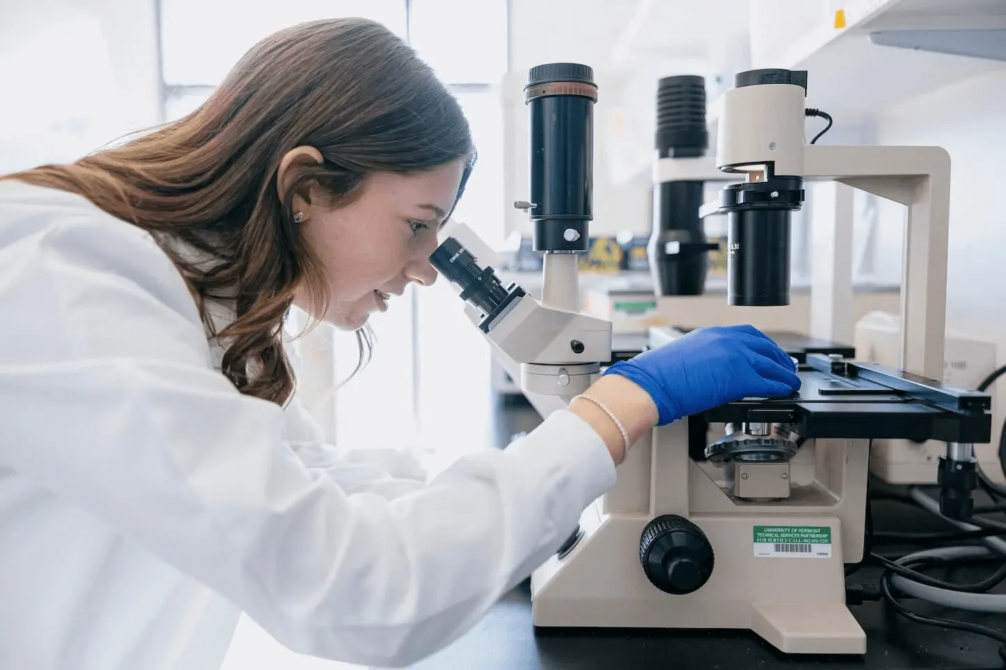 a wman looking into a microscope