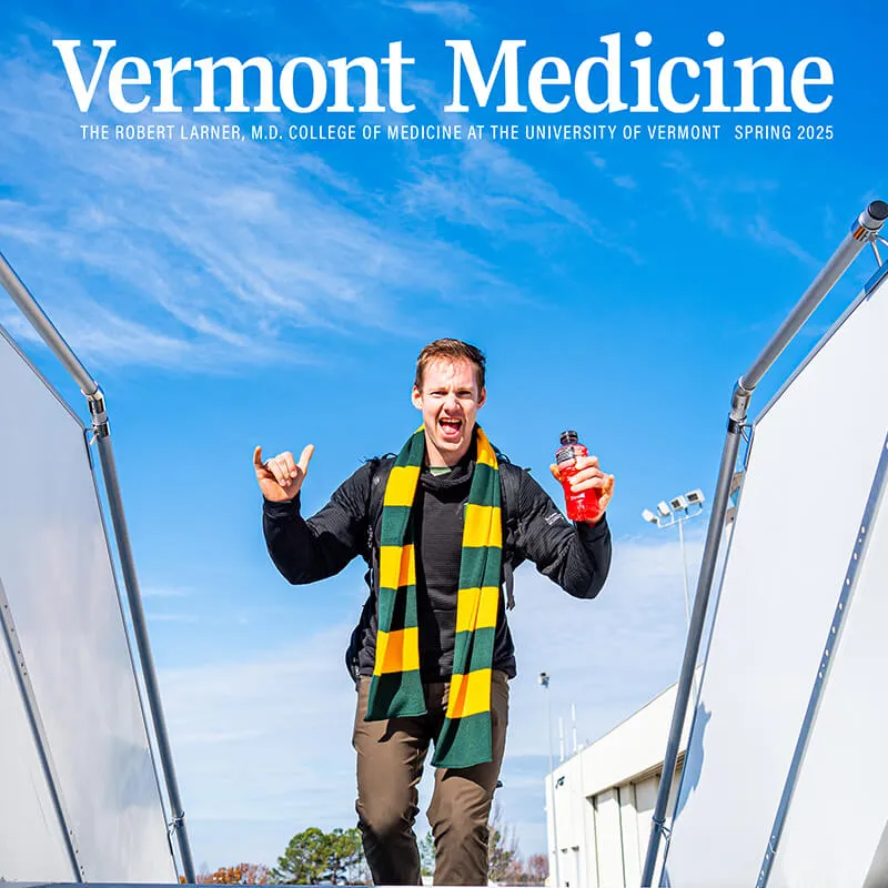a happy man with a green and yellow scarf reaches the top of a staircase 