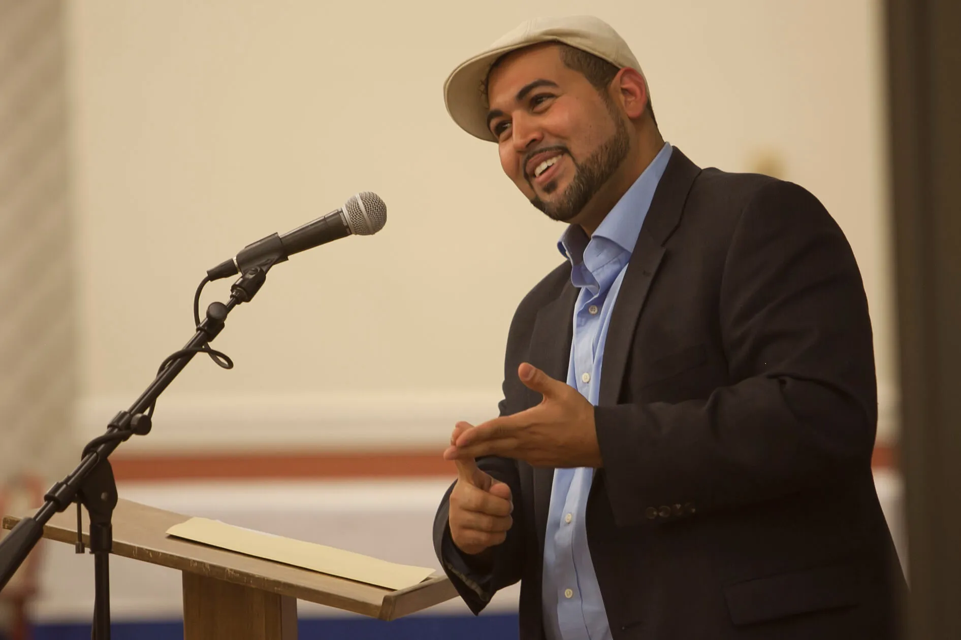 Dr. Benitez smiling while speaking and leaning against a podium