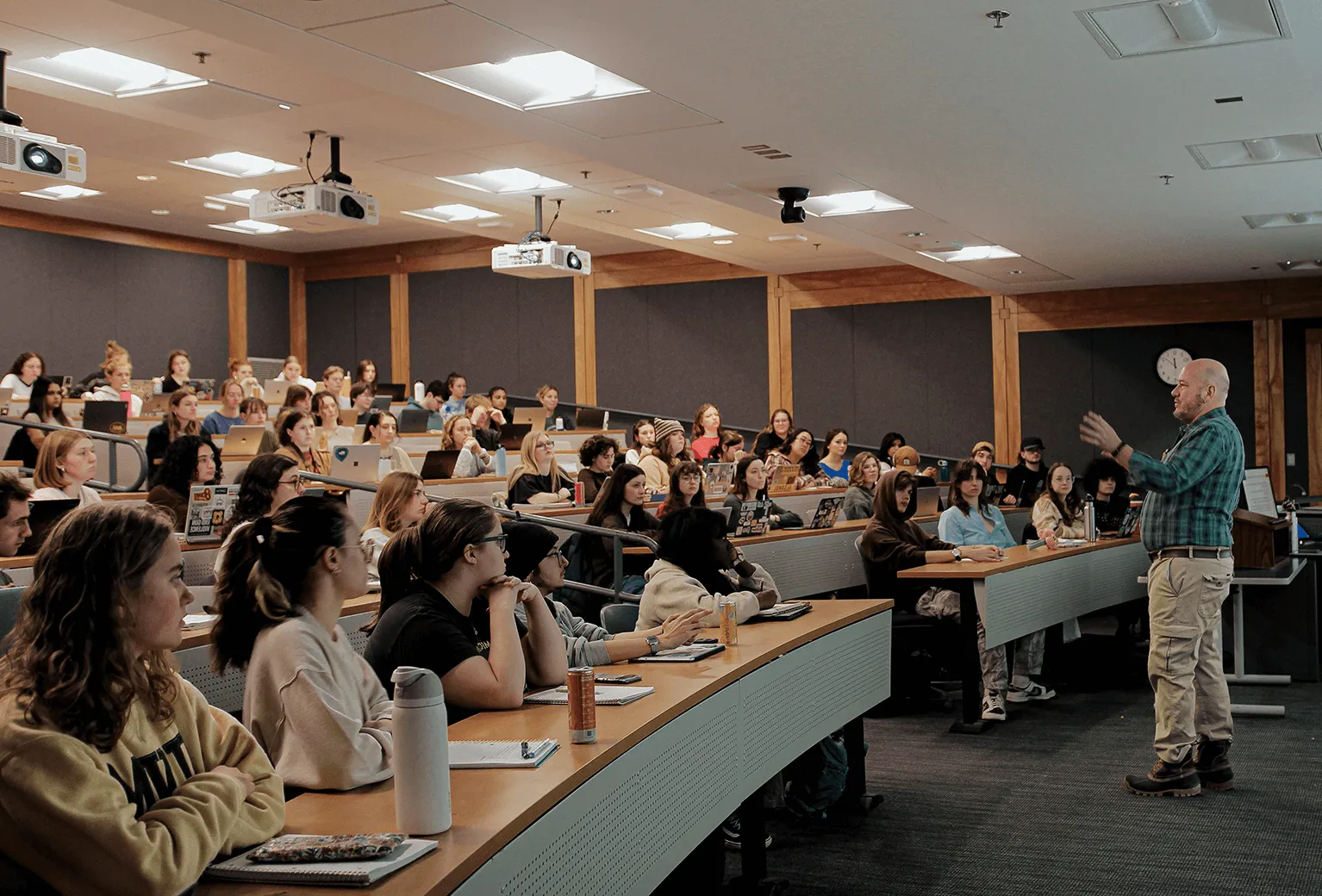 Instructor giving a lecture to a large classroom of students.