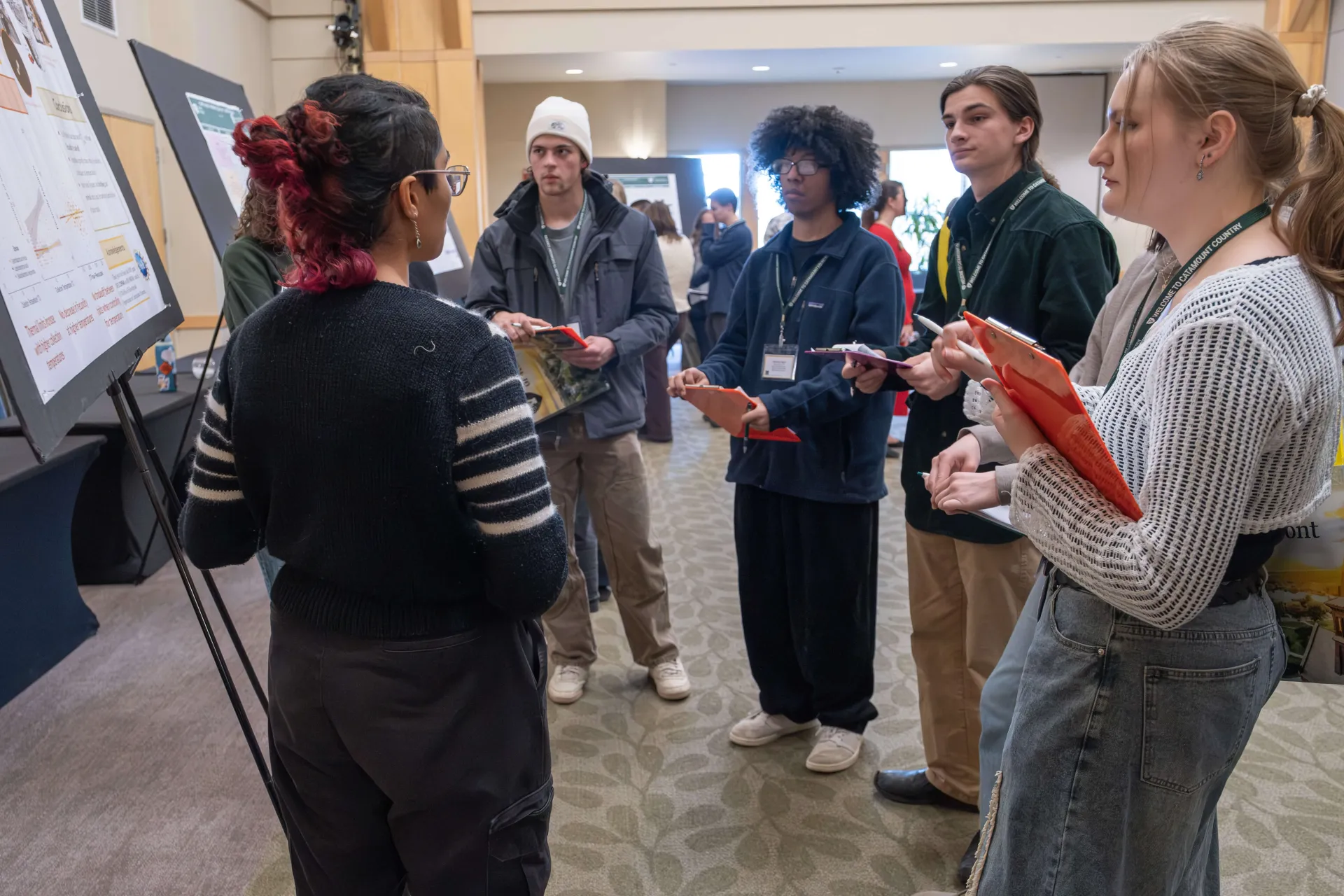 Students gather around a presentation board