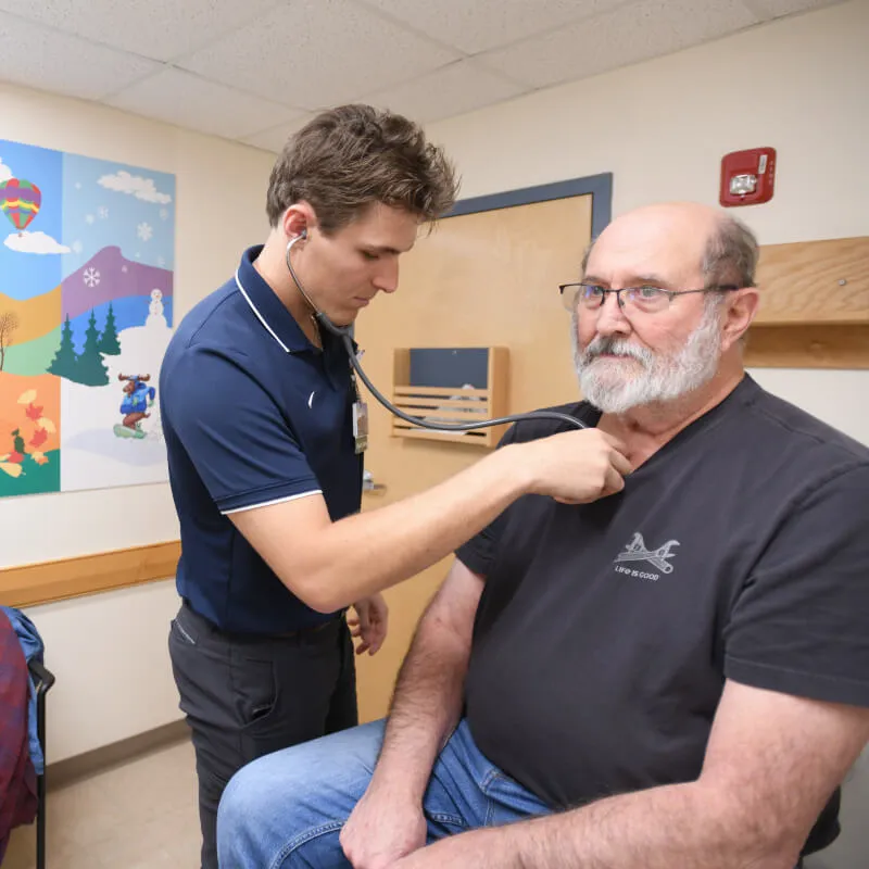 doctor listens to patients heart in an office