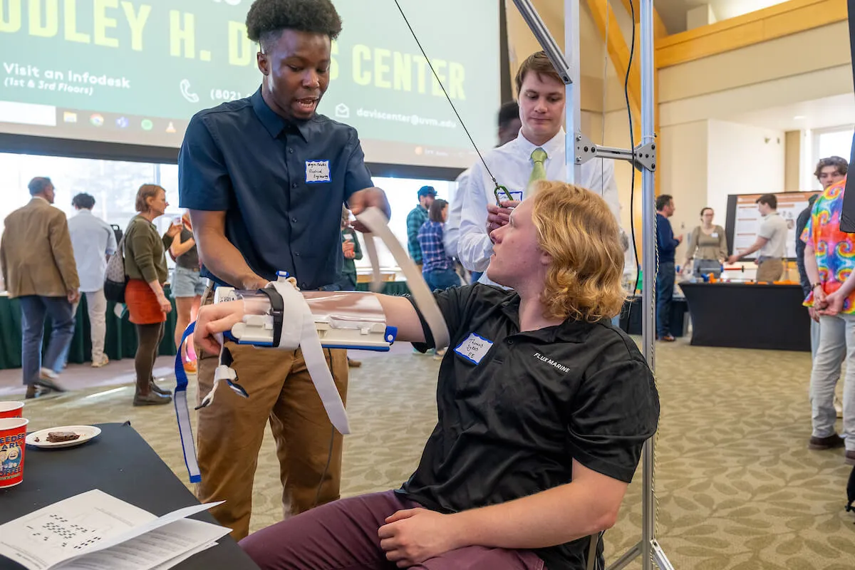 A student demonstrates his senior project, an arm device to improve patient mobility