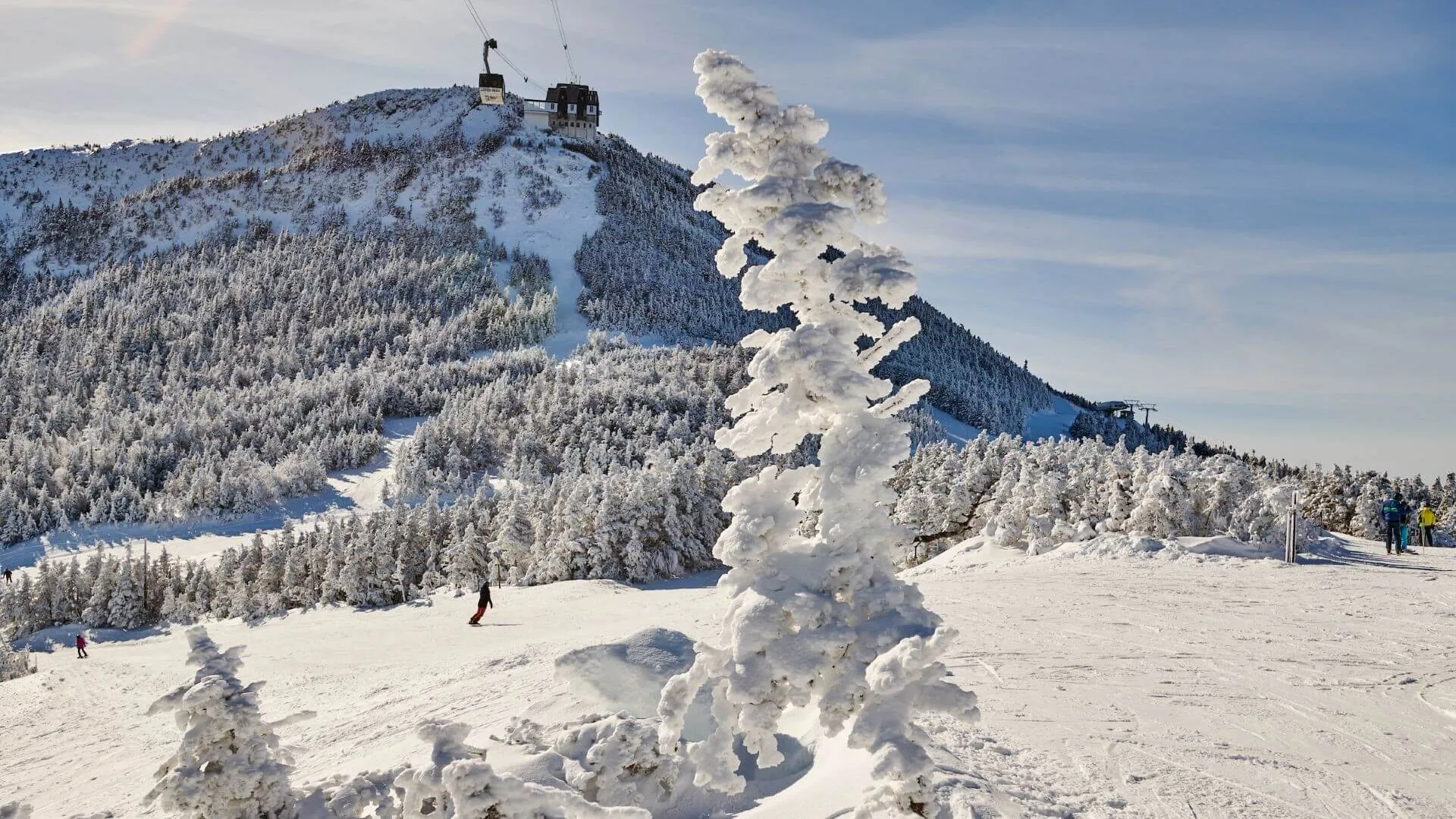 Stowe Mountain Ski Resort - a view of the gondola at the top of the mountain on a bluebird day during the winter